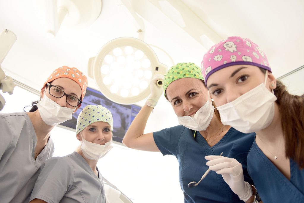 تیم کلینیک دندانپزشکی که روی ایمپلنت دندان کار می کنند